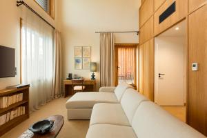 a living room with a white couch and a television at Grand Mess Clermont-Ferrand in Clermont-Ferrand