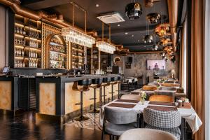 a restaurant with a bar with tables and chairs at Auris Hotel & Restobar in Almaty