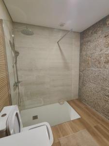 a bathroom with a shower and a white toilet at Gondar Stays Estúdio 