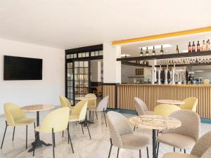 a restaurant with tables and chairs and a bar at Ona Diana Park in Estepona