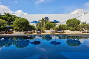 a pool at a resort with chairs and umbrellas at Park Inn by Radisson Davao in Davao City