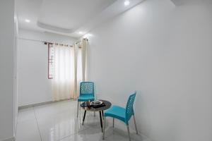 a dining room with two chairs and a table at FabHotel Blue Birds in Bangalore