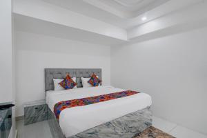 a white bedroom with a bed in a room at FabHotel Blue Birds in Bangalore