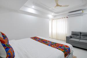a bedroom with a bed and a couch at FabHotel Blue Birds in Bangalore