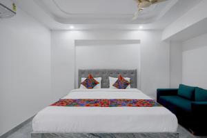 a bedroom with a large bed and a blue couch at FabHotel Blue Birds in Bangalore