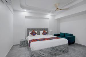 a bedroom with a large bed and a blue couch at FabHotel Blue Birds in Bangalore +23 photos