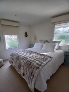 a bedroom with a large white bed with a window at Via Bella Vista in Wangaratta