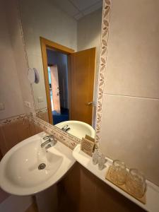 ein Badezimmer mit Waschbecken und Spiegel in der Unterkunft Hotel La Guindal in Les Arriondes + 21 Fotos