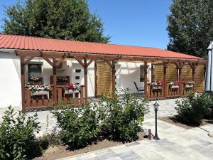 a wooden pavilion with chairs and flowers on it at Samu Tanya in Gyula