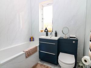 a bathroom with a toilet and a sink and a tub at 6 Niddrie Marischal Road in Edinburgh +12 photos