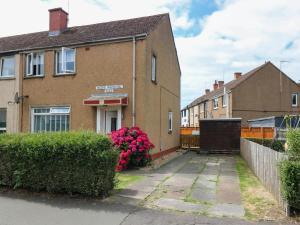a brick house with pink flowers in front of it at 6 Niddrie Marischal Road in Edinburgh