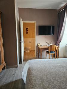 a hotel room with a bed and a table and a desk at Chambres d'hôtes -- Le Clos de Gémozac in Gémozac