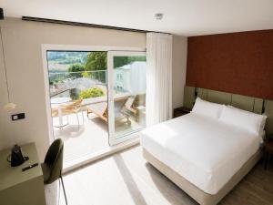 ein Schlafzimmer mit Bett und Balkon in der Unterkunft Hotel Henko in Portomarin