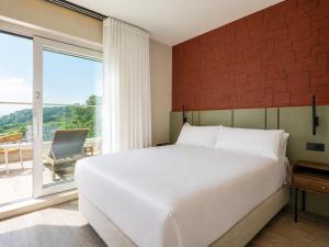 ein Schlafzimmer mit einem großen weißen Bett und einem großen Fenster in der Unterkunft Hotel Henko in Portomarin + 29 Fotos