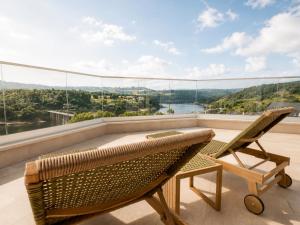 ein Balkon mit Stuhl, Tisch und Aussicht in der Unterkunft Hotel Henko in Portomarin