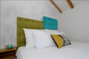 a bed with a green headboard and white pillows at Wellnes Villa Silentio With Pool in Duge Njive +33 photos