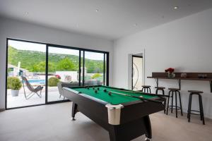 a billiard room with a pool table in a house at Wellnes Villa Silentio With Pool in Duge Njive