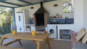 a kitchen with a wooden table and a washing machine at Cortijo el Puente in Viñuela