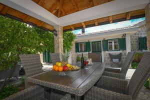 a table with fruit on it on a patio at Wellnes Villa Silentio With Pool in Duge Njive
