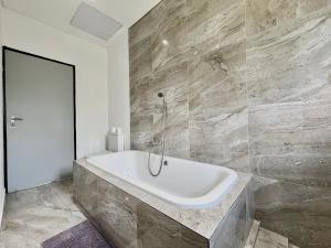 a white bath tub in a bathroom with marble walls at Number 12, Jadde apartments in Sandton +20 photos