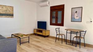 a living room with a couch and a table and a tv at Golondrinas Verdes in Huelva