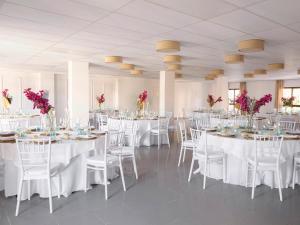 a room with white tables and white chairs and pink flowers at Ona Diana Park in Estepona +35 photos