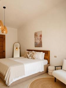 a bedroom with a large white bed and a chair at CASA BUKO Tropical Homes El Nido in El Nido