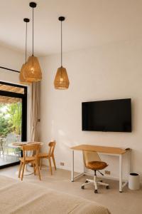 a living room with a table and a tv at CASA BUKO Tropical Homes El Nido in El Nido