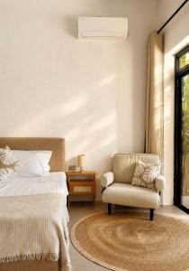 a bedroom with a bed and a chair and a window at CASA BUKO Tropical Homes El Nido in El Nido +15 photos