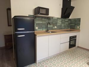 a kitchen with a black refrigerator and a microwave at As Casiñas da Mina in Fechas +3 photos