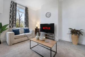 a living room with a couch and a tv at NEW! Spacious 4BR in Sidney in Bishop Auckland +35 photos