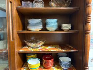 a cabinet filled with plates and bowls and dishes at Haraya in Nakatsugawa