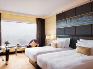 a hotel room with two beds and a window at StarWorld Hotel in Macau