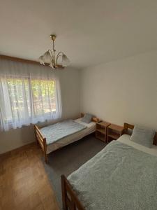 a bedroom with two beds and a window at Šumska kuća Juga Kovačević in Bela Crkva