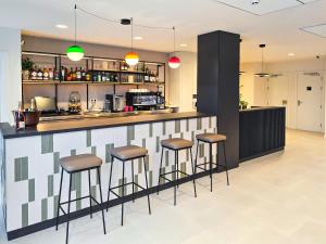 a bar in a restaurant with stools at DWO San Sebastián in San Sebastián