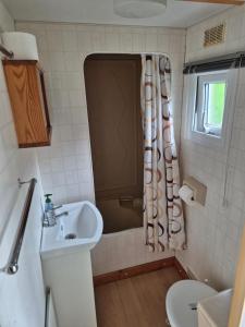 a bathroom with a sink and a shower curtain at Juno Holiday in Mrągowo