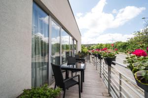 ein Balkon mit Tisch, Stühlen und Blumen in der Unterkunft Mikado Hotel in Nitra