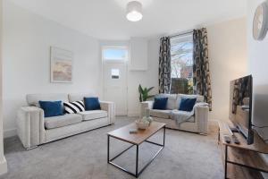 a living room with two couches and a tv at NEW! Spacious 4BR in Sidney in Bishop Auckland