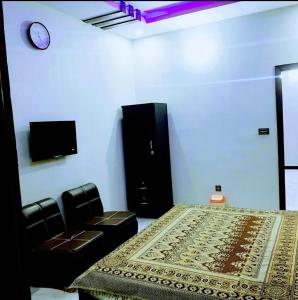 a room with a bed and a clock on the wall at Galaxy Family Hotel Karachi Airport in Karachi