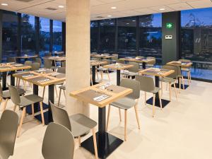 a restaurant with tables and chairs and windows at DWO San Sebastián in San Sebastián