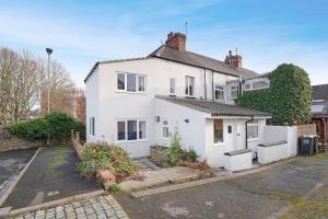 a white house with a parking lot at NEW! Spacious 4BR in Sidney in Bishop Auckland