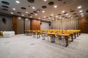ein Konferenzraum mit Tischen und gelben Stühlen in der Unterkunft Mikado Hotel in Nitra