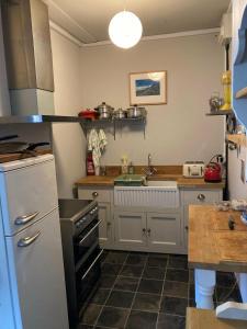 a kitchen with a sink and a stove top oven at Step-free modern central apartment in Todmorden