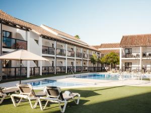 a hotel with a pool and two chairs and an umbrella at Ona Diana Park in Estepona
