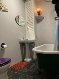 a bathroom with a tub and a toilet and a sink at Step-free modern central apartment in Todmorden +10 photos