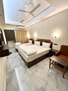 a bedroom with two beds and a table and a couch at Hotel Fivetel in kolkata