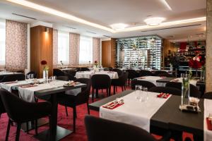 ein Restaurant mit Tischen und Stühlen in einem Raum in der Unterkunft Mikado Hotel in Nitra