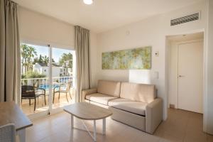 a living room with a couch and a table at Cabot Club Torreblanca in Sa Coma