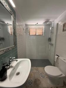 a white bathroom with a sink and a toilet at Dafne's Beach in La Pineda +28 photos