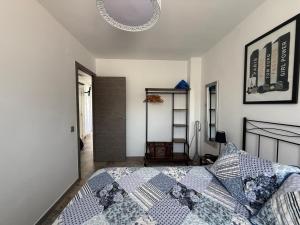 a bedroom with a bed with a blue and white quilt at Dafne's Beach in La Pineda